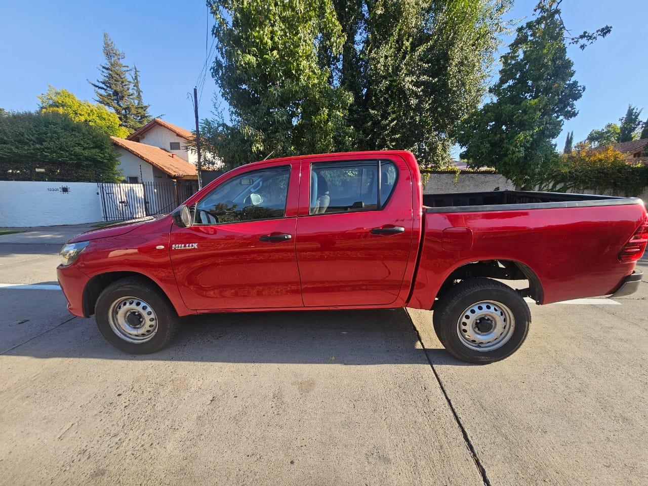 Vista lateral Toyota Hilux DX 2024 despeje de suelo y neumáticos originales